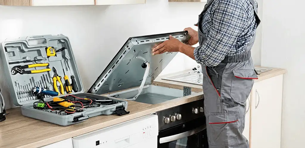Handyman repairing a cooktop and checking wiring connections in Austin, TX