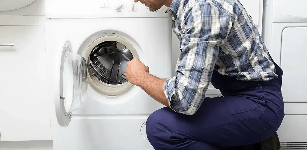 Handyman inspecting a dryer drum and internal parts for repair in Austin, TX