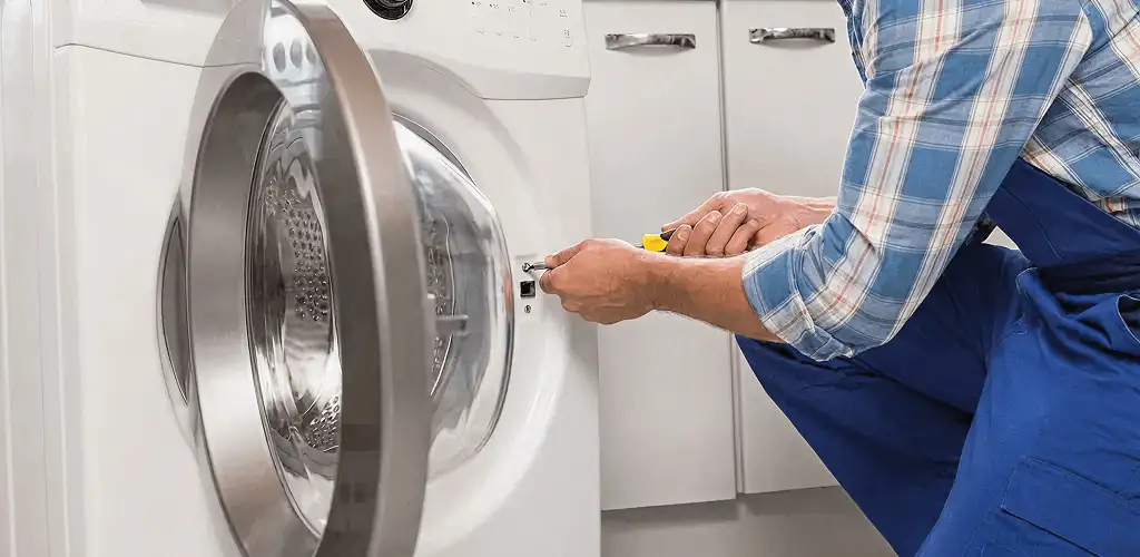 Handyman repairing a clothes dryer and checking electrical connections in Austin, TX
