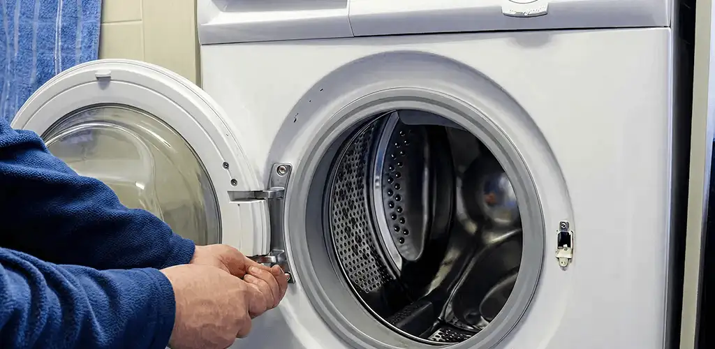 Washing machine repair handyman checking a front-load washer door and latch in Austin, TX