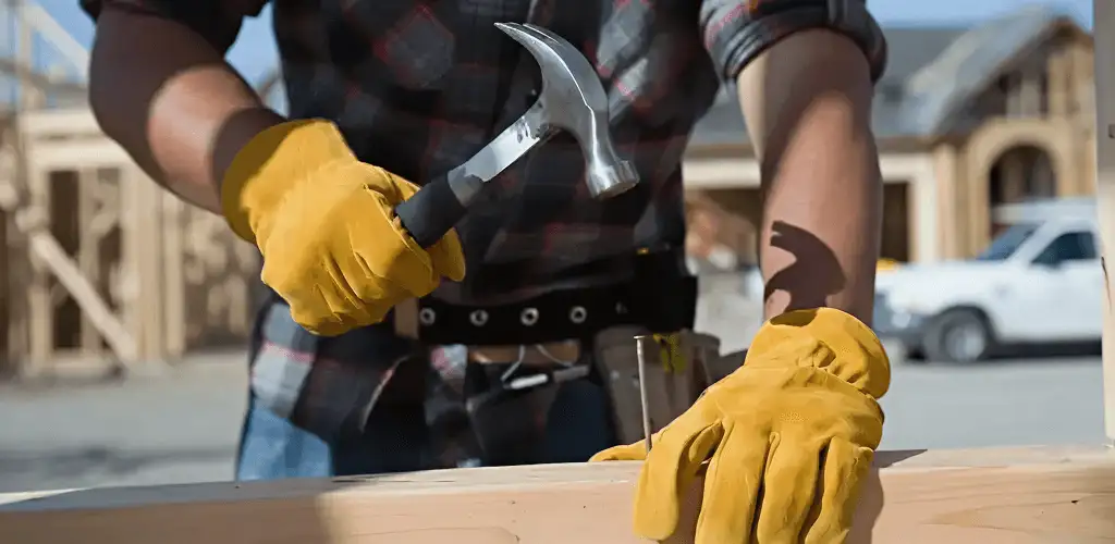 Handyman fixing wood trim with a hammer for home repairs in Austin, TX