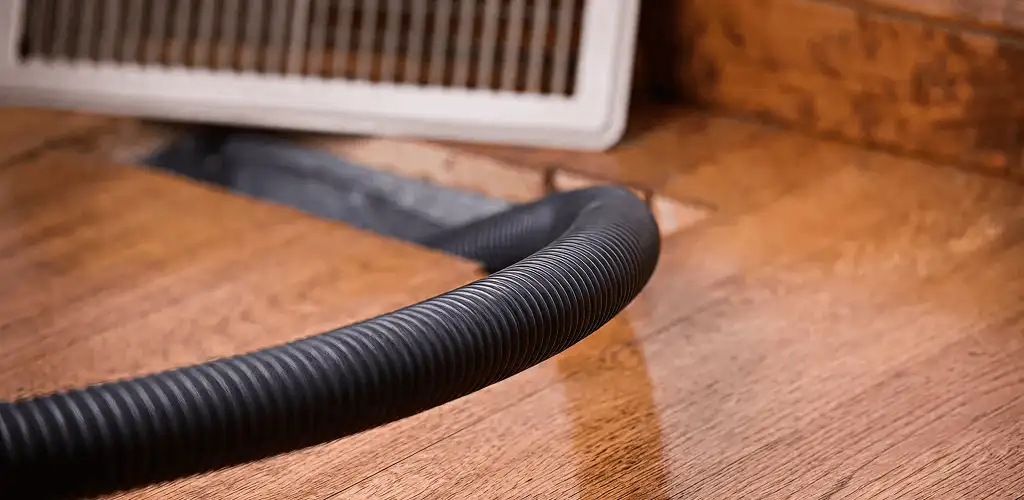 Air duct cleaning hose inserted into a floor vent for ductwork cleaning in Austin, TX