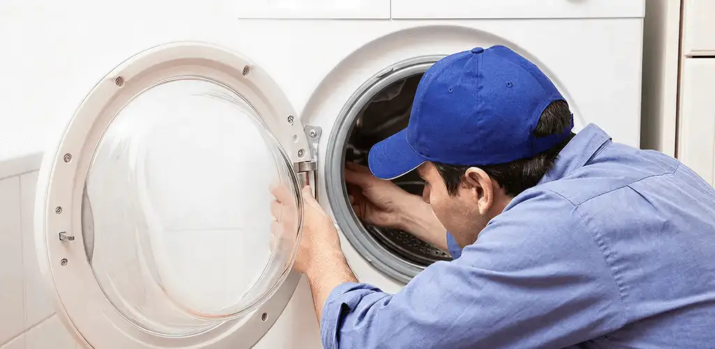 Washing machine repair handyman inspecting a front-load washer drum in Austin, TX